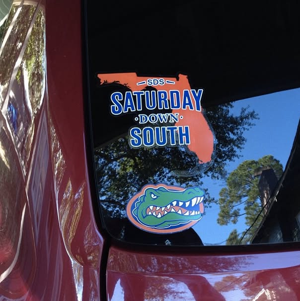 A Saturday Down South decal beside a Florida Gators decal on a vehicle window